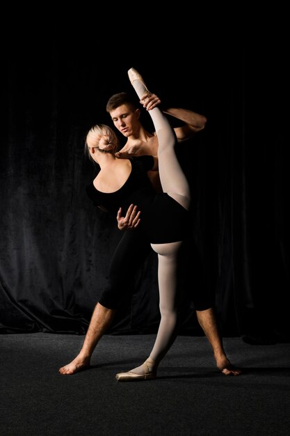 Ballet couple stretching in ballet outfits