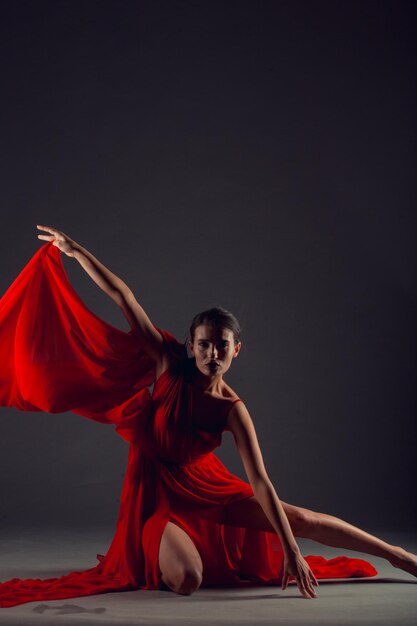 Ballet dancer or classic ballerina dancing isolated on dark background