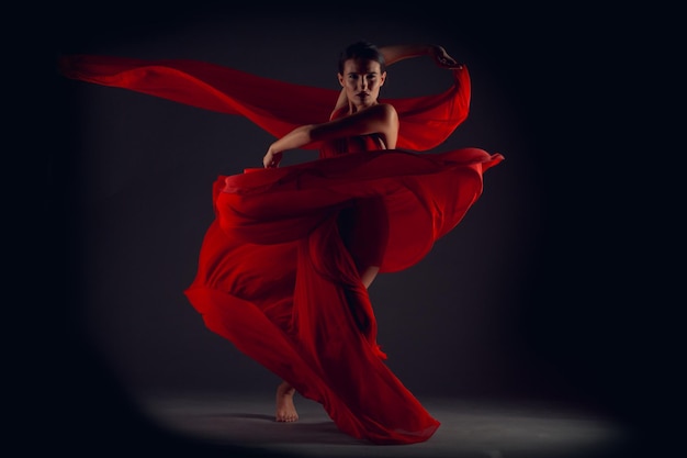 Ballet dancer or classic ballerina dancing isolated on dark background