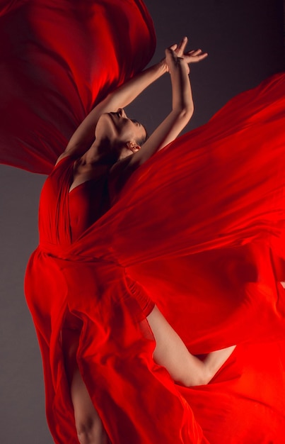 Ballet dancer or classic ballerina dancing isolated on dark background