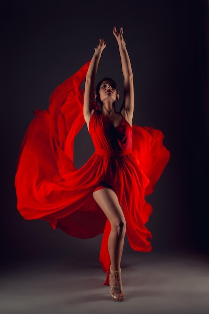 Ballet dancer or classic ballerina dancing isolated on dark background