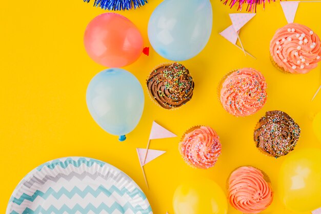 Balloons and cupcakes near plate