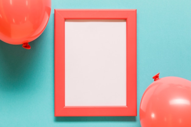 Balloons and empty frame on blue background