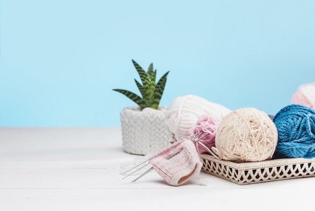 balls of wool on white wooden background