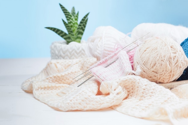 balls of wool on white wooden background