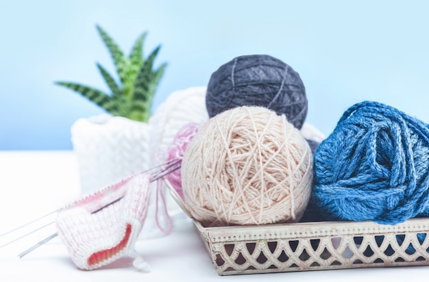 The balls of wool on white wooden background