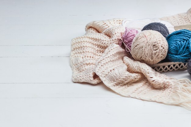 The balls of wool on white wooden surface