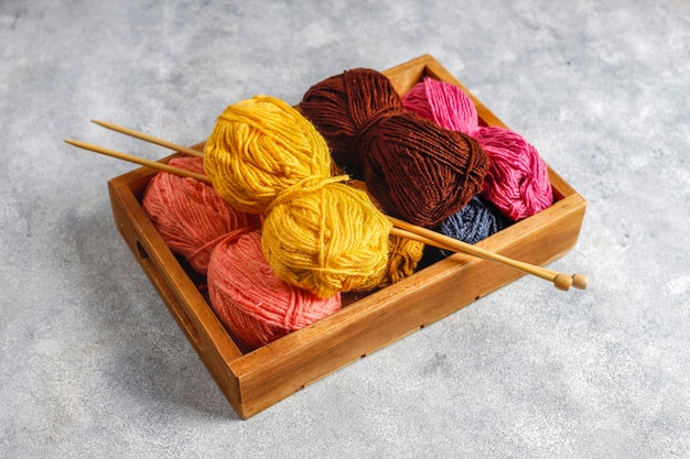 Foto gratuita gomitoli di filato in diversi colori con ferri da maglia.
