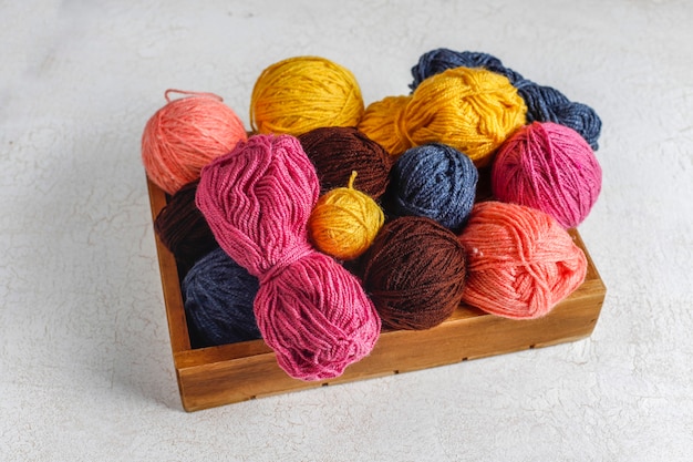 Balls of yarn in different colors with knitting needles.