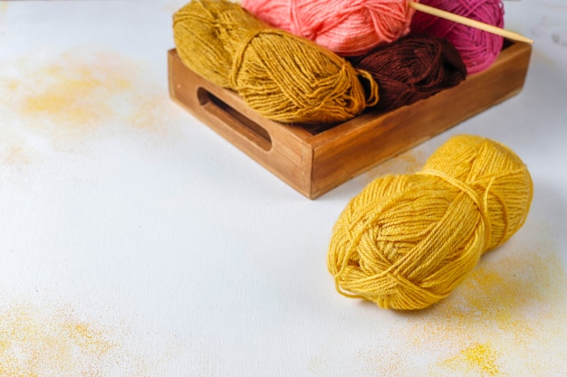 Balls of yarn in different colors with knitting needles.