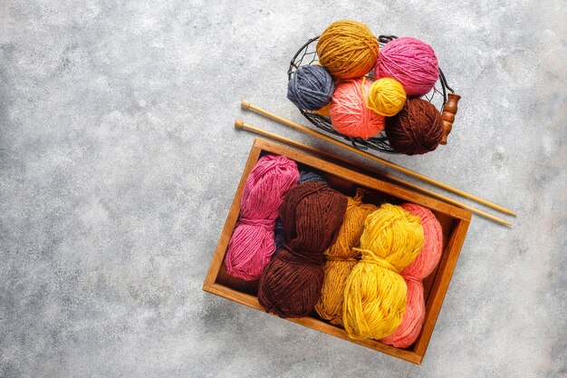 Balls of yarn in different colors with knitting needles.