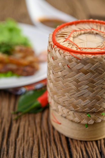 Bamboo box for putting sticky rice on a wooden table