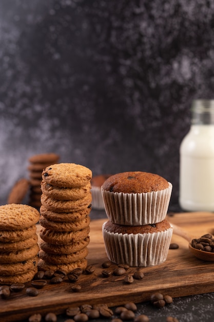 Banana cupcakes that are placed on a wooden plate with coffee grains.