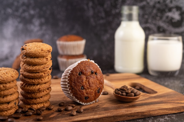 コーヒーの穀物が付いている木の皿に置かれるバナナのカップケーキ。