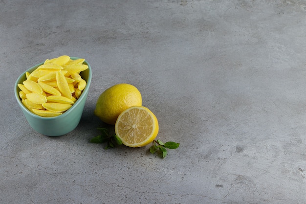 Banana shaped chewing candy with fresh lemon and mint leaves