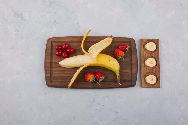 バナナ、イチゴ、ベリーの真ん中にある木製の大皿