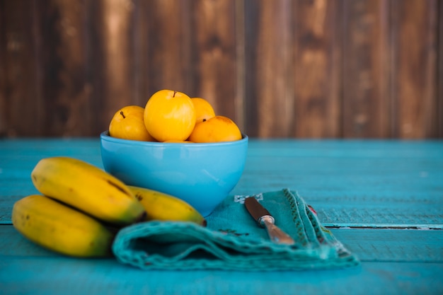 青い木製の表面にバナナ広告の新鮮な梅
