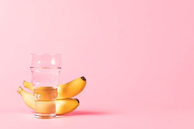 Bananas and water glass copy space