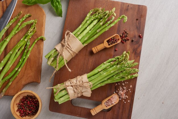 Banches of fresh green asparagus on wooden surface