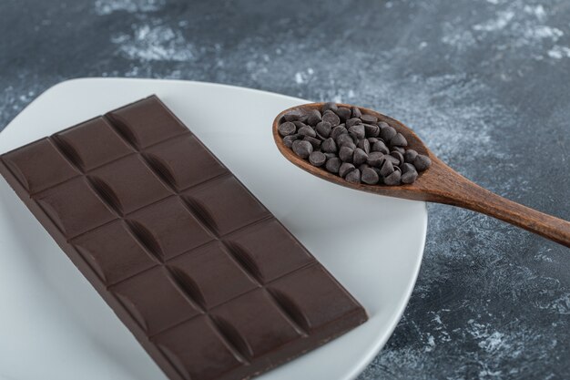 大理石の表面にチョコレートチップが入ったチョコレートのバー。