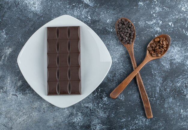 Bar of chocolate with coffee beans and chocolate chips .