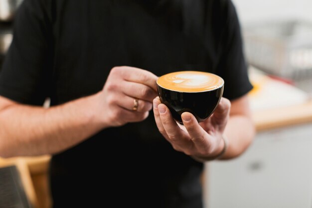 Bar concept with barman holding coffee cup