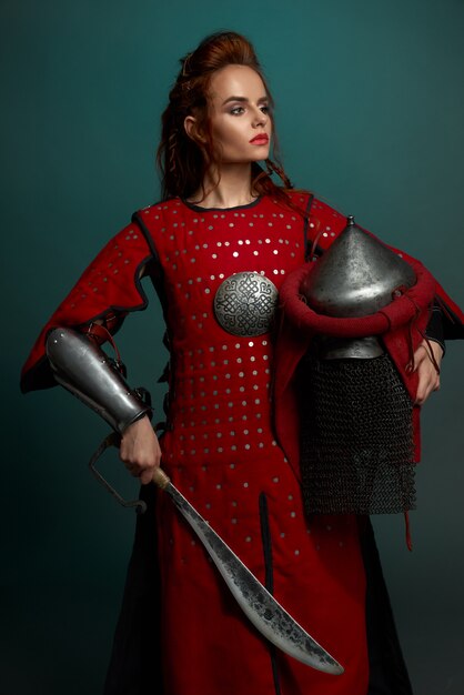 Варварский женский боец позирует с шлемом и ножом