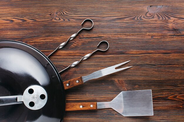 Barbecue appliance and utensil on wooden textured