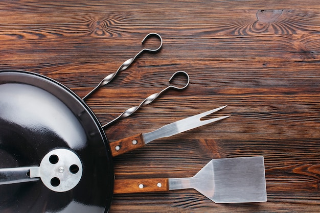 Barbecue appliance and utensil on wooden textured