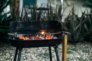 Free photo barbecue burning charcoal in yard of house