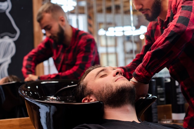 Barber carefully washing client head 