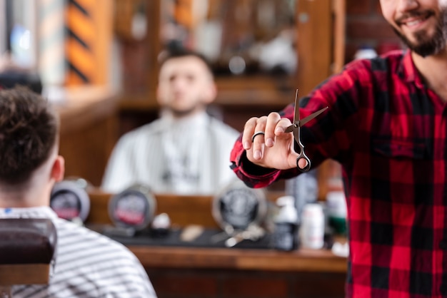 Free photo barber holding scissors in his right hand