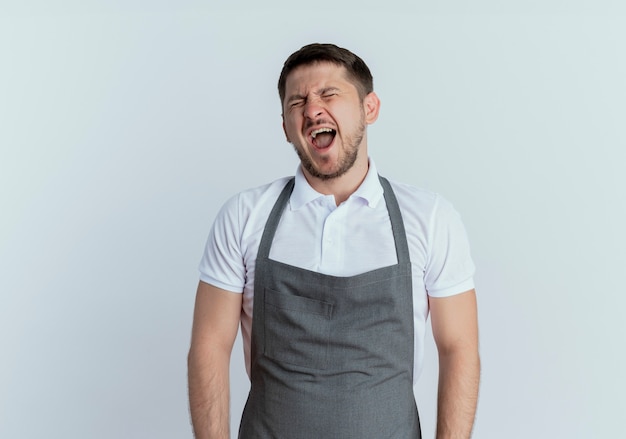 barber man in apron looking tired yawning standing over white wall