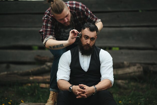 Barber shaves a bearded man in vintage atmosphere