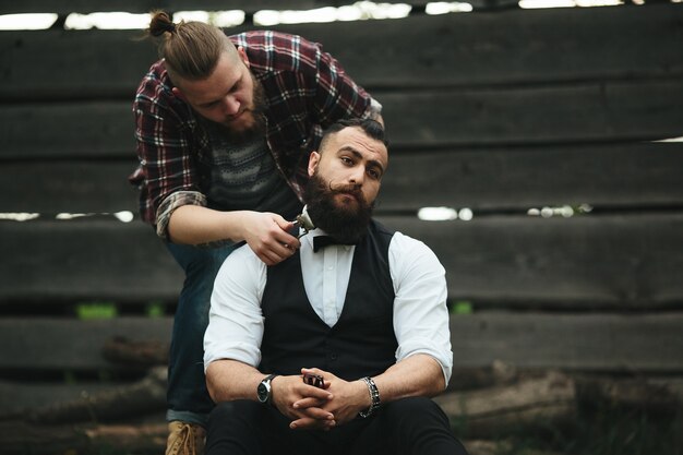 Парикмахер бреет бородатого мужчину в винтажной атмосфере