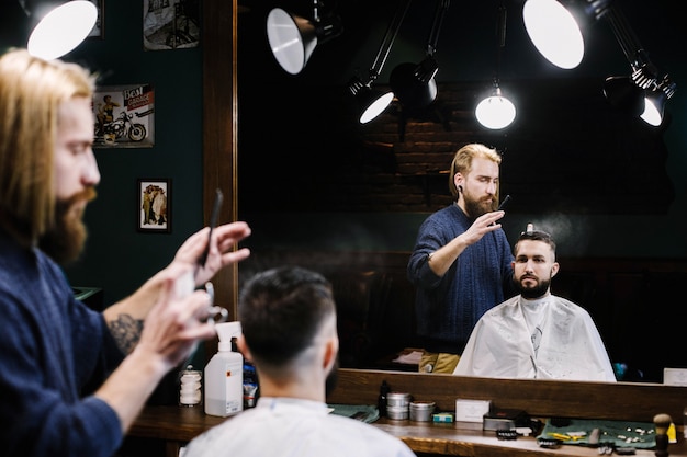 Free photo barber sprays water on the hair