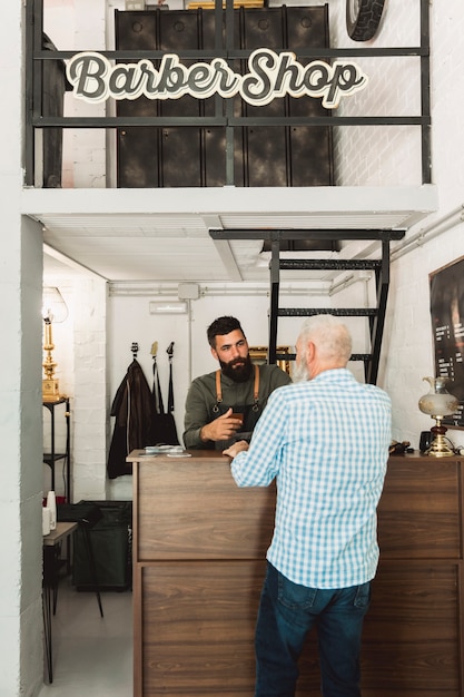 Barber talking with client at reception desk