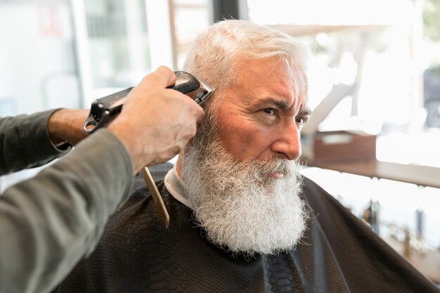 Barber trimming client in salon