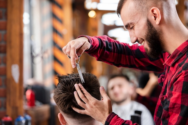 Barber using scissors to make a hairstyle