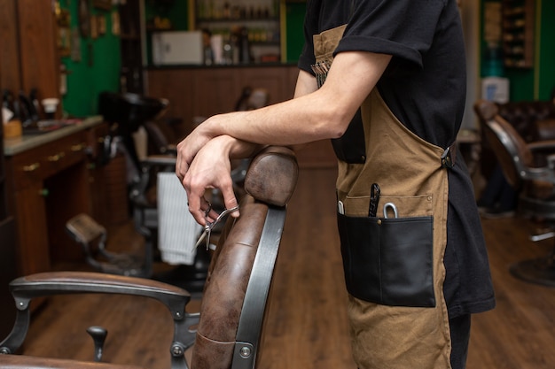 Barber with scissors in barbershop