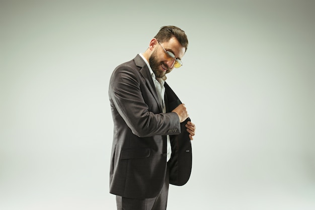 The barded man in a suit holding leather purse