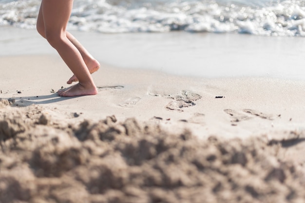 Barefoot child playing by the seaside