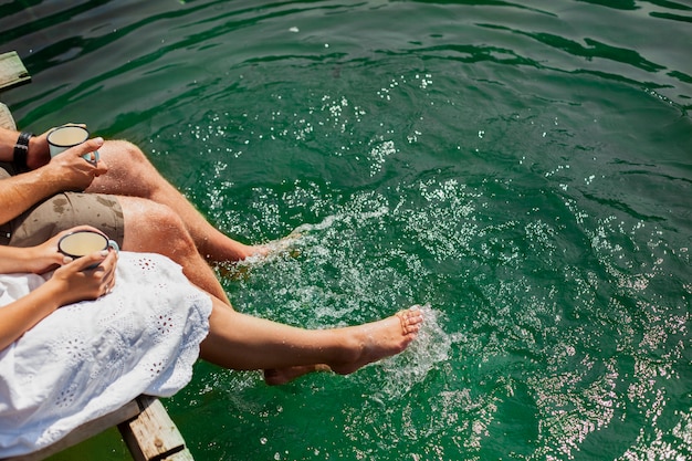 Foto gratuita coppia a piedi nudi tenendo tazze di caffè