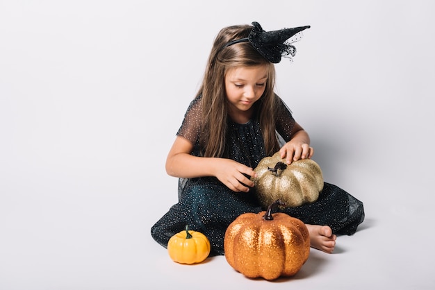 Free photo barefoot witch playing with pumpkins