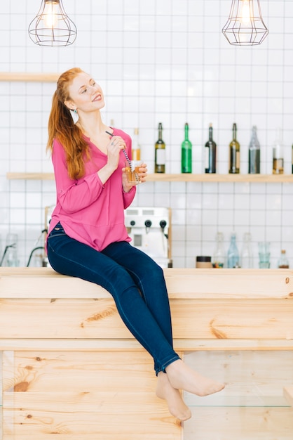 Donna a piedi nudi sul bancone del bar