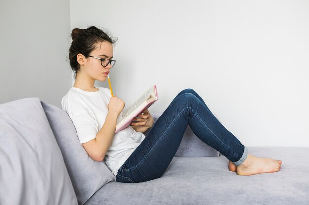 Barefoot woman reading and thinking