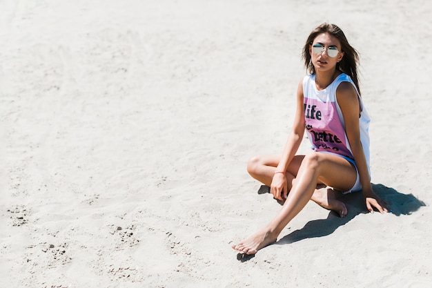 Free photo barefoot woman relaxing on beach