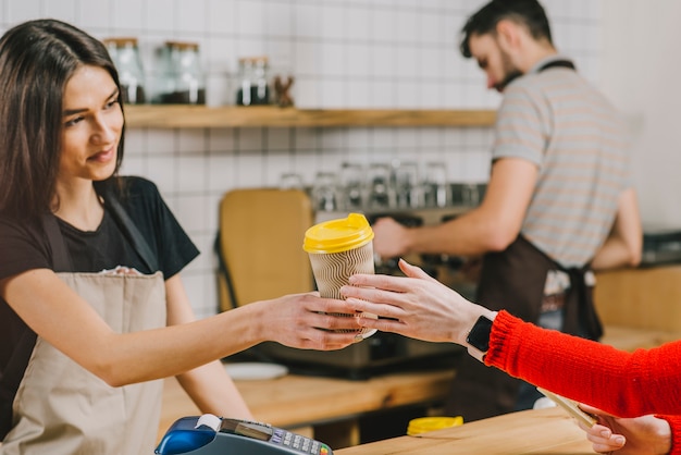 Barista giving drink to customer