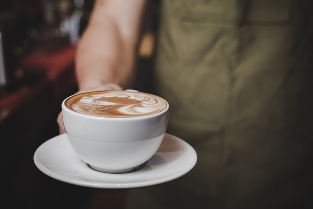 Barista handling Hot Cafe Latte.