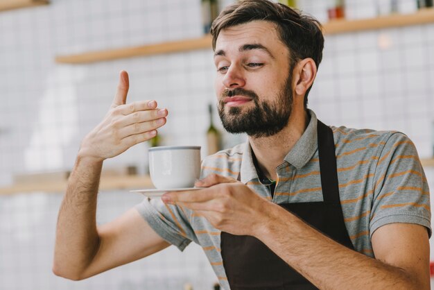 ホットドリンクを嗅ぐバーリスタ